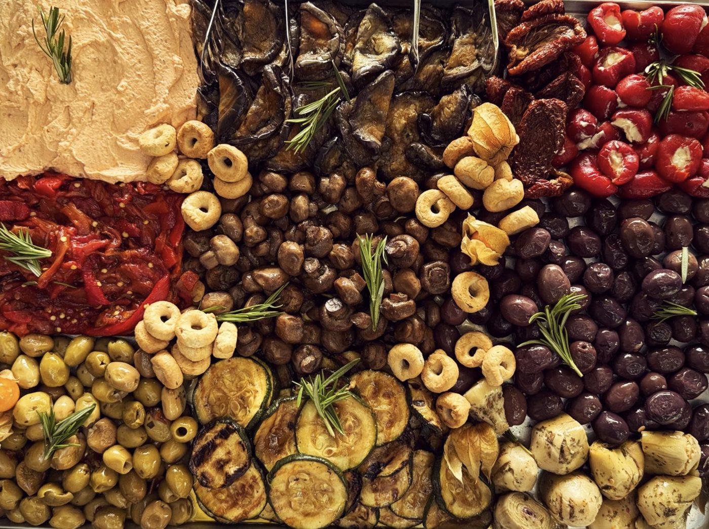 Antipasti von oben: Oliven, gegrillte Zucchini und Auberginen, Champignons, gefüllte Paprika, getrocknete Tomaten, Artischocken und Taralli