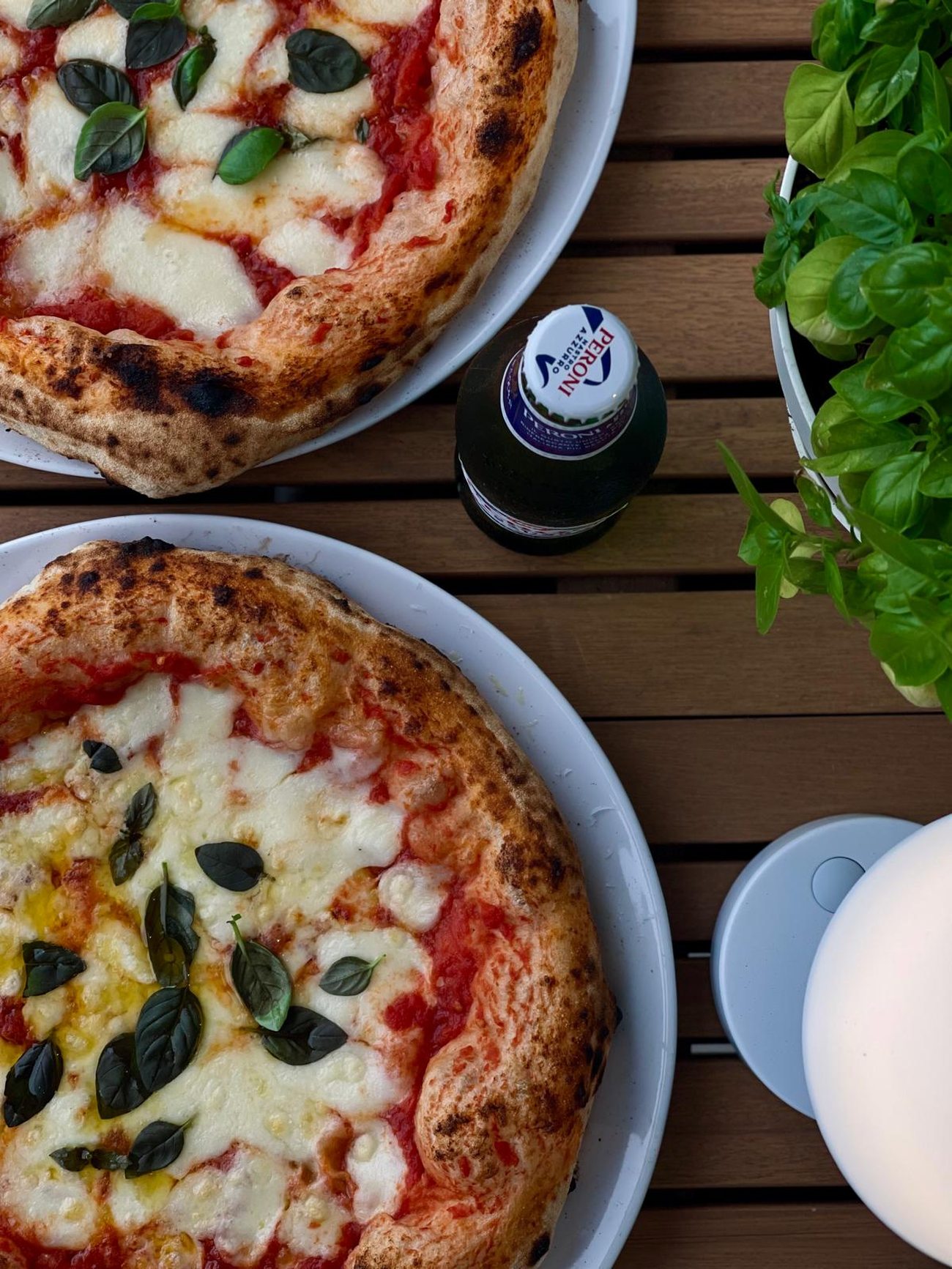 Zwei Margheritas auf Tellern mit einer Flasche Peroni